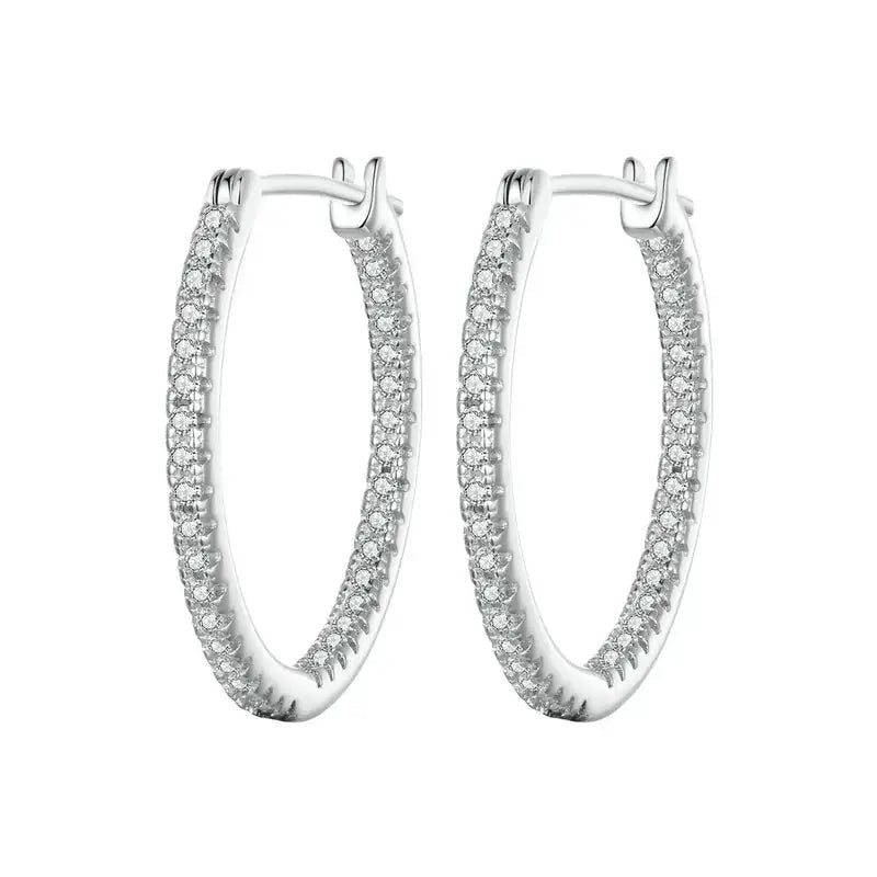 A pair of silver hoop earrings paved with small clear stones, shown against a plain white background.