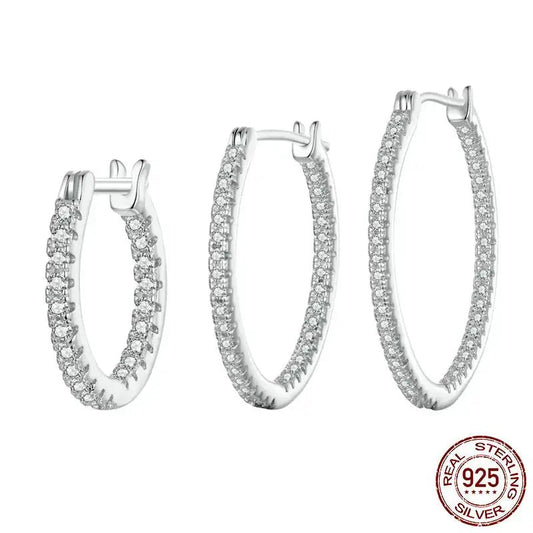 Set of silver hoop earrings with clear stones on a white background, featuring a 'Real Sterling Silver 925' stamp.
