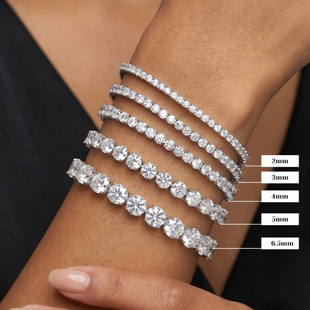 Five silver tennis bracelets on a wrist, with round-cut stones and size labels from 2mm to 6.5mm