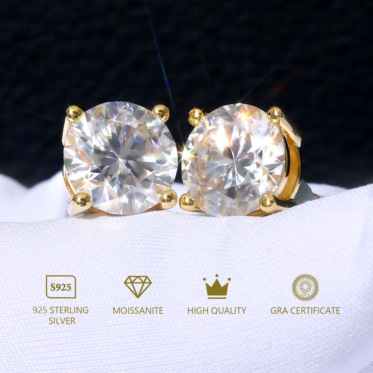 Gold stud earrings with clear gemstones on a white surface, featuring certification logos.