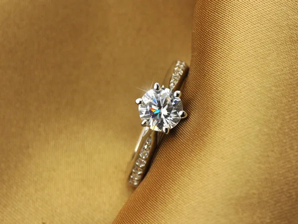Diamond ring on a gold fabric background
