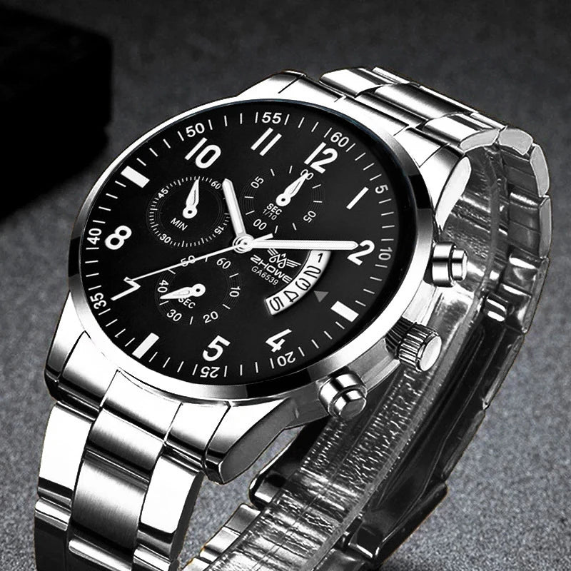 A silver stainless steel wristwatch with a black dial, Arabic numeral markers, and a folding clasp.