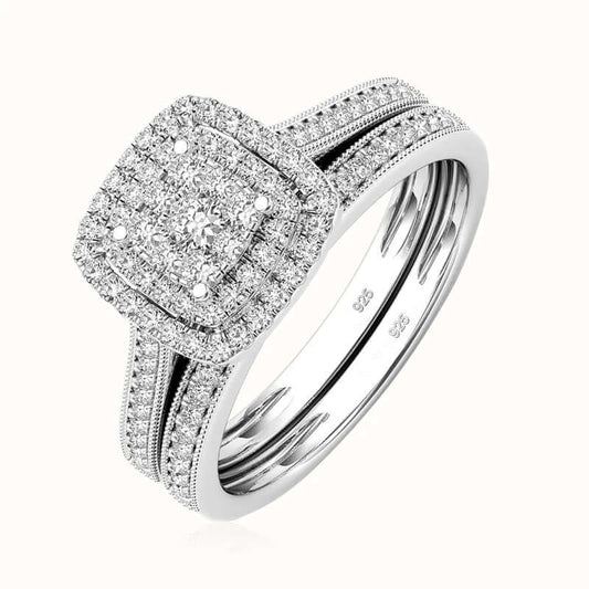 A silver-toned diamond engagement ring with a cushion-shaped halo and a matching band, shown on a clean white background.