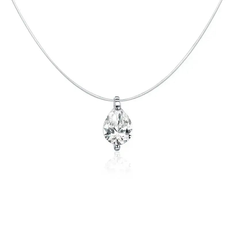 A silver necklace with a thin chain and a pear-cut clear gemstone pendant in a prong setting, shown on a white background with a soft reflection below.